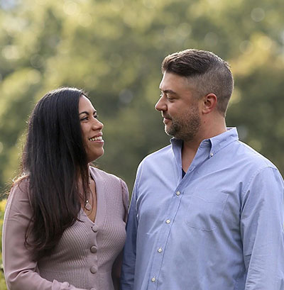 Kevin and his wife looking at each other lovingly in an outdoor space