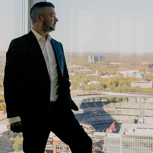 Kevin looking out of a suite window at Truist ballpark